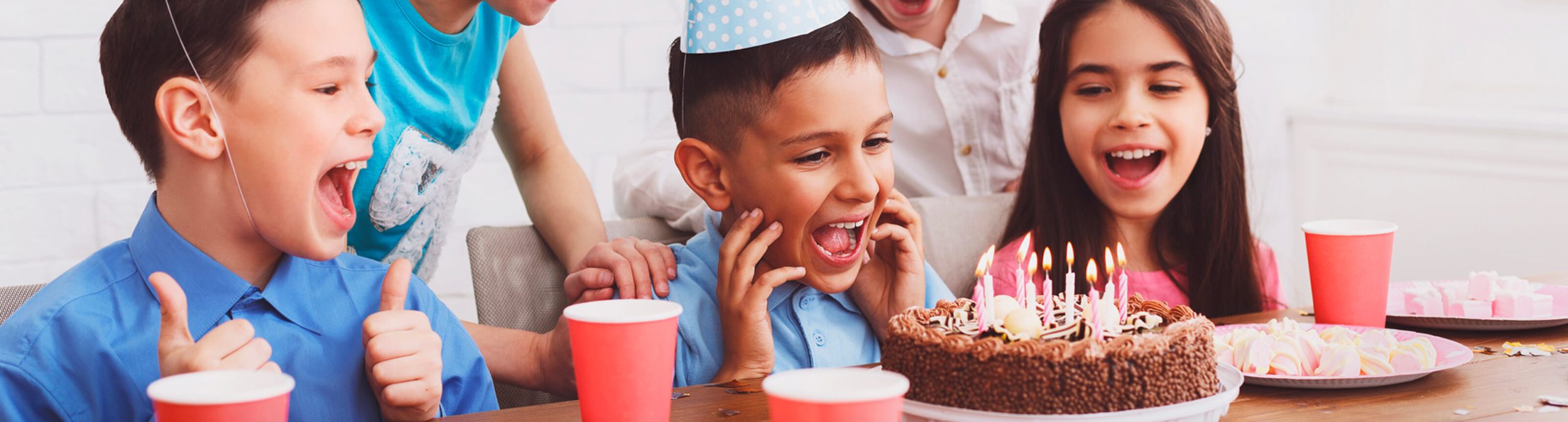 Imagen de cabecera de la sección "Reservas" en la que aparecen unos niños con una tarta de cumpleaños